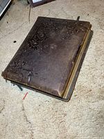 Closed embossed leather photo album showing exterior wear
