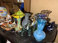 Group view of all eight art glass pieces on shelf