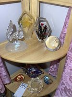 Assorted glass items on two corner shelves