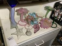 Group shot of all ten art glass items on cabinet