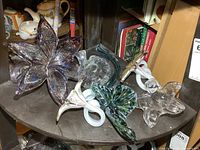 Shelf with five glass flower sculptures showing variety
