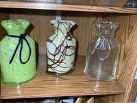 Group shot of three matching shape vases on shelf