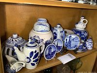 Shelf view of entire grouping showing ginger jar, warmer, rooster teapot, small plates, bottle and creamer