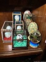 Shelf containing assorted decorative eggs in various display cases