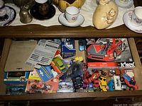 Full drawer view showing mixed loose and packaged vehicles and K’Nex box