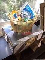 Floral basket with sealed Happy Meal toys resting on box labeled Workload