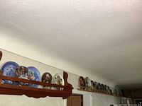 Long shelf showing many decorative plates lined up