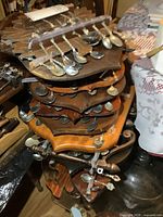 Stack of multiple wooden spoon racks filled with souvenir spoons