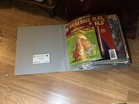 Grey binder opened showing French Brisebois comic and other issues
