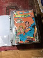 Binder open showing Supergirl comic in plastic sleeve