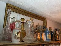 Shelf with multiple glass and ceramic decanters and bottles