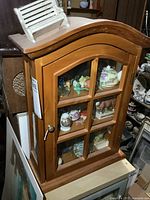 Front view of wood cabinet showing contents through glass door