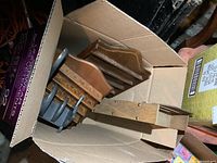 Box containing multiple wooden display shelves