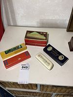 Five boxed harmonicas on tabletop