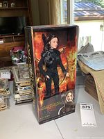 Front view of boxed Katniss doll showing figure and artwork