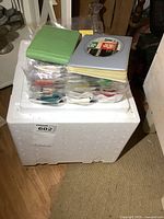 Bin with plastic bags of matchbooks and two small albums stacked on top