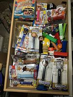 Drawer containing packaged and loose PEZ dispensers plus jumbo Homer head visible