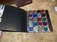 Open binder showing right page with 20 colorful NHL pogs