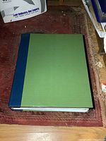Closed binder showing green cover and blue spine