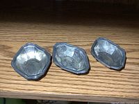 Three Birks sterling silver nut dishes on shelf