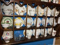 Full view of shelving with 18 teacup and saucer sets