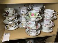 Shelf holding floral bone china teacups stacked on matching saucers