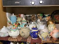 Overall view of upper shelf collection of teapots, mugs and pitcher