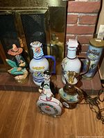 Group shot of assorted decorative decanter bottles and blue tin