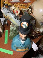 Front view Prince Edward Island bust decanter, fish and swan decanters partially visible