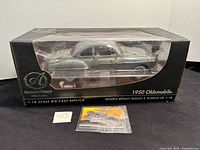 Boxed Ertl American Muscle Authentics 1950 Oldsmobile model with sealed insert visible