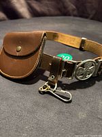 Full view of brown leather belt with coin pouch, GGC buckle and metal clip