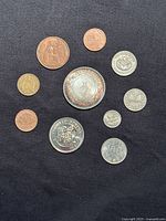 Obverse sides of ten assorted world coins and token on black background