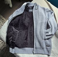 Cardigan opened to show gray knit exterior and black fleece lining