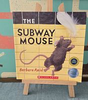 Cover of The Subway Mouse by Barbara Reid on easel