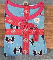 Joe Fresh penguin print pajama set folded with red ribbon, size L/G 10-12 label visible