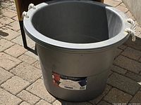 Full view of gray plastic tub showing interior and rope handles