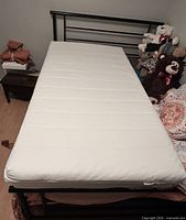 Full view of mattress on bed frame showing overall condition