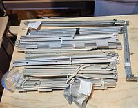 Stack of bundled metal drawer slides with bags of fasteners