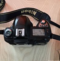 Top view Nikon D70 body showing mode dial, LCD, strap attached