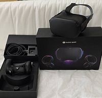 Headset, controllers, cable, adapter and original box displayed together