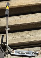 Full side view of folded razor kick scooter on steps