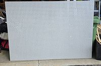 Full view of white pegboard panel