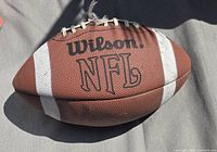 Wilson NFL football showing deflation and missing lace
