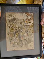 Full frontal view of the framed art print lying flat, showing nude figure, tree, fruits, and signature with black frame.