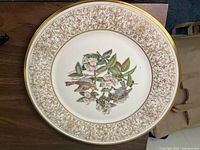 Full view of the Lenox Boehm Birds porcelain plate showing golden floral border and central Wood Thrush bird illustration.