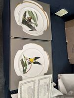 Set of two Ray Harm collector plates in original boxes, showing Winter Wren and American Goldfinch with certificates of authenticity.