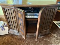 Front view of the Fisher Philharmonic console stereo with double doors open, showing the built-in turntable and stereo receiver controls