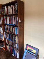 Full front view of the wooden bookcase filled with books to show structure and shelf use.