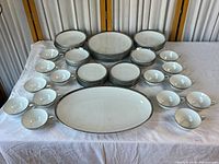 Full lot overview showing all plates, bowls, saucers, cups, and platter