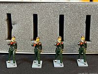 four metal soldier figurines in foam tray